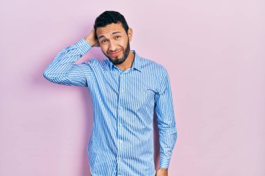 Sıradan mavi gömlek giyen İspanyol sakallı adam soru sorup şaşırıyor. Şüpheyle kararsız, kafa kafaya düşünerek. Düşünceli kavram. 