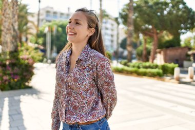 Genç İrlandalı kız gülümsüyor, mutlu bir şekilde şehirde duruyor..