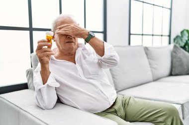 Son sınıf öğrencisi elinde haplarla gözlerini kapatıyor, ciddi ve üzgün görünüyor. Görme, saklama ve reddetme konsepti 