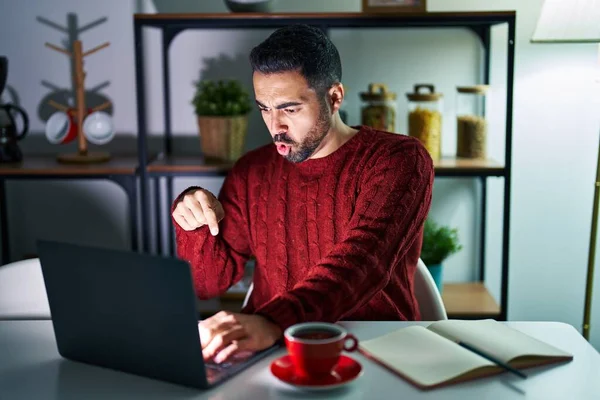 Mladý Hispánec Plnovousem Který Noci Doma Používá Notebook Ukazuje Prstem — Stock fotografie