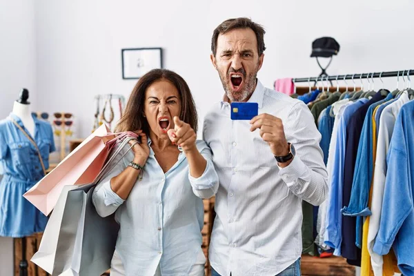 Hispanic Middle Age Couple Holding Shopping Bags Credit Card Pointing — ストック写真