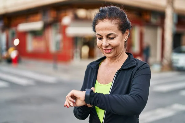 Middle Age Hispanic Woman Working Out Smart Watch Outdoors — Stok fotoğraf