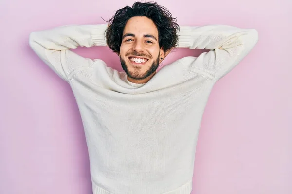 カジュアルな白いセーターを着たハンサムなヒスパニック系の男がリラックスしてストレッチ 腕と手の後ろに頭と首の笑顔幸せ — ストック写真
