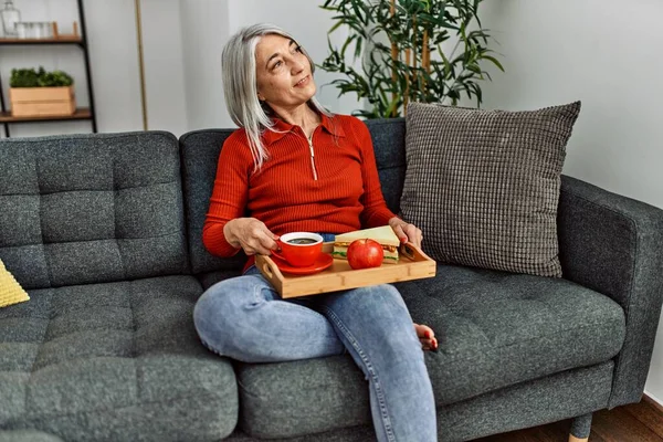 Mujer Pelo Gris Mediana Edad Desayunando Sentada Sofá Casa —  Fotos de Stock