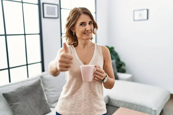 Donna Mezza Età Che Beve Una Tazza Caffè Casa Approvando — Foto Stock