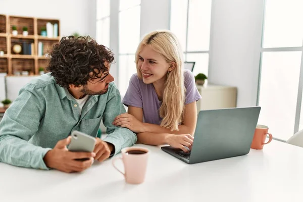 Unga Par Använder Laptop Och Smartphone Dricka Kaffe Hemma — Stockfoto