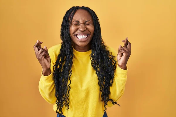 African Woman Standing Yellow Background Gesturing Finger Crossed Smiling Hope — Photo