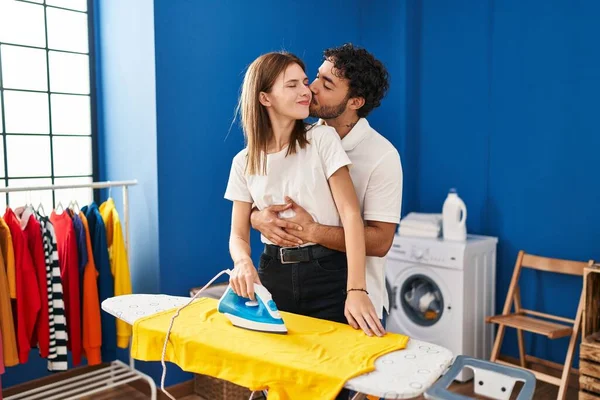 男男女女在洗衣房互相拥抱熨烫衣服 — 图库照片