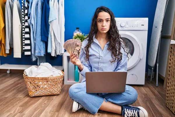 Young Brunette Woman Doing Laundry Using Laptop Holding Money Depressed — Stockfoto