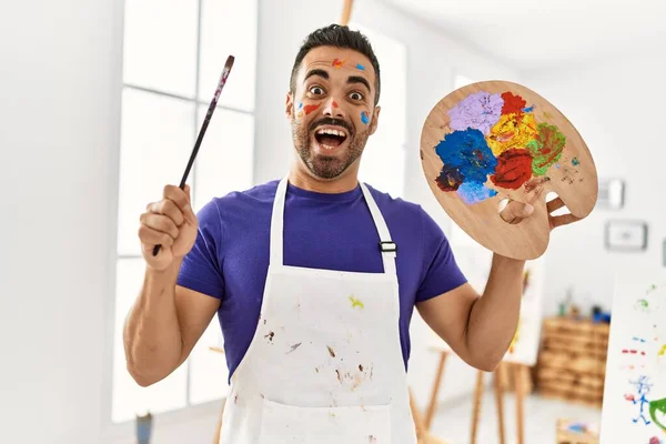 Joven Hombre Hispano Sonriendo Confiado Sosteniendo Pincel Paleta Estudio Arte — Foto de Stock