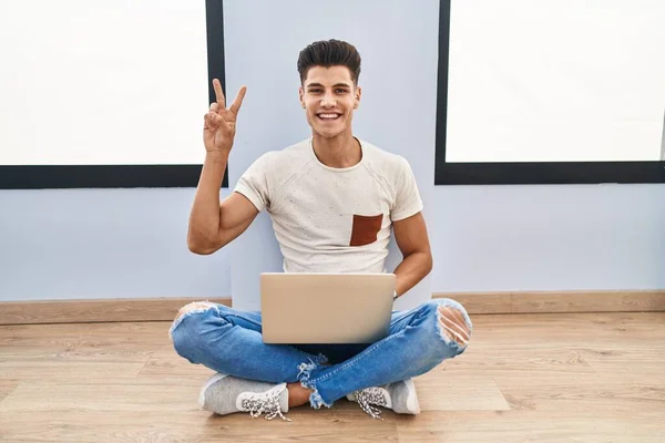 Νεαρός Ισπανός Που Χρησιμοποιεί Φορητό Υπολογιστή Στο Σπίτι Χαμογελώντας Κοιτάζοντας — Φωτογραφία Αρχείου