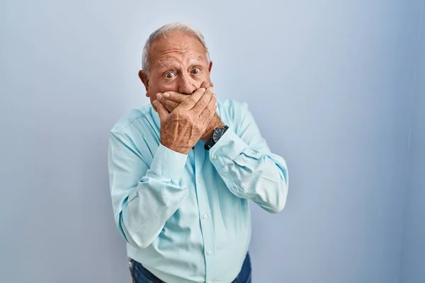 Senior Man Grey Hair Standing Blue Background Shocked Covering Mouth — Stockfoto