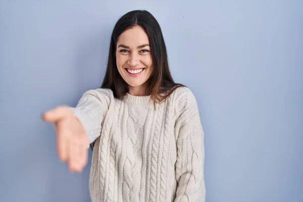 Genç Esmer Kadın Mavi Arka Planda Duruyor Gülümsüyor Avuç Içi — Stok fotoğraf