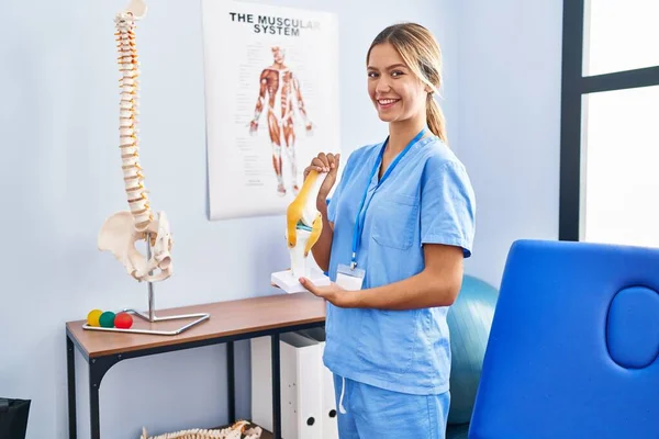 Jovem Loira Ortopédica Segurando Modelo Anatômico Articulação Joelho Sorrindo Com — Fotografia de Stock