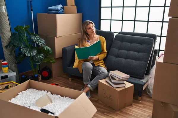 Joven Mujer Rubia Sentada Sofá Escribiendo Libro Casa Nueva — Foto de Stock