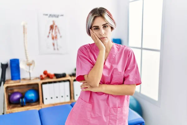 Young Nurse Woman Working Pain Recovery Clinic Thinking Looking Tired —  Fotos de Stock