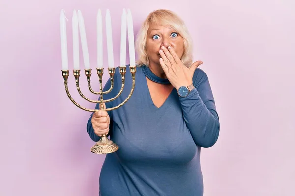 Middle Age Blonde Woman Holding Menorah Hanukkah Jewish Candle Covering — Stok fotoğraf