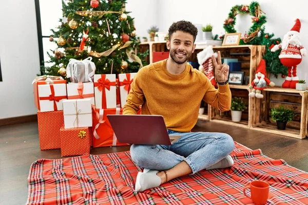 Joven Árabe Usando Portátil Sentado Junto Árbol Navidad Sonriendo Mirando — Foto de Stock