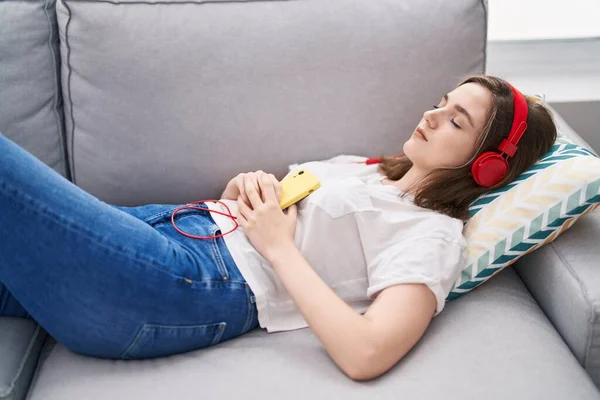 Young Woman Listening Music Sleeping Sofa Home — Stockfoto