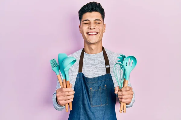 Jovem Hispânico Vestindo Avental Profissional Padeiro Segurando Ferramentas Cozinha Sorrindo — Fotografia de Stock