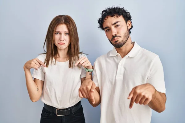 Young Couple Wearing Casual Clothes Standing Together Pointing Looking Sad —  Fotos de Stock