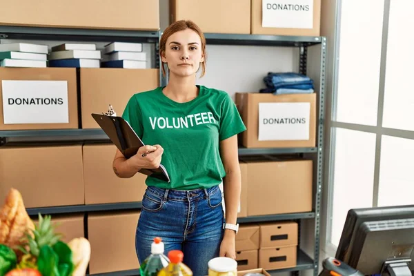 Bağışlarda Gönüllü Tişört Giyen Genç Esmer Kadın Yüzünde Ciddi Bir — Stok fotoğraf