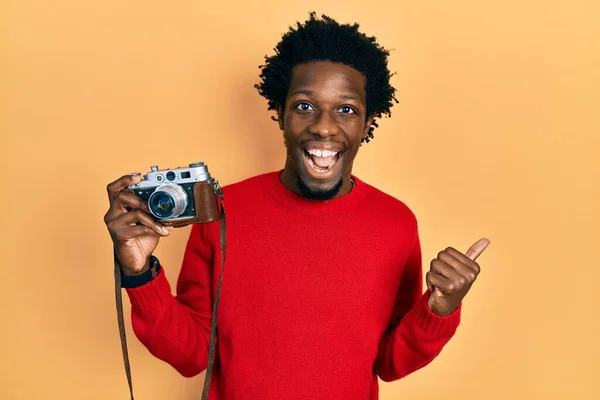 若いですアフリカ系アメリカ人男性ホールドヴィンテージカメラ指して親指へザ側笑顔幸せとともにオープン口 — ストック写真