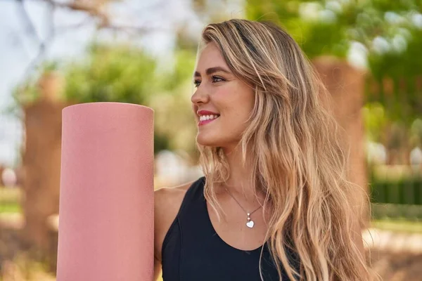 Mujer Joven Sonriendo Confiada Sosteniendo Estera Yoga Parque —  Fotos de Stock