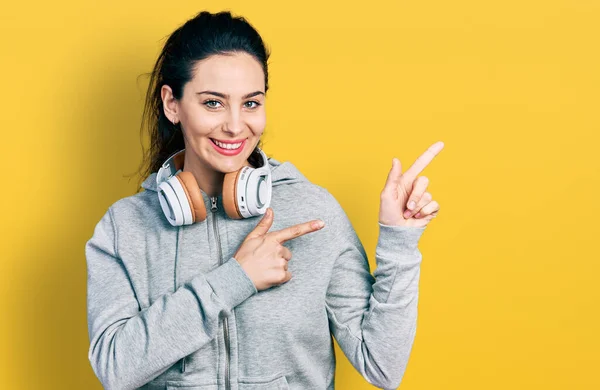 Jonge Spaanse Vrouw Draagt Sportkleding Gebruikt Een Glimlachende Koptelefoon Kijkt — Stockfoto
