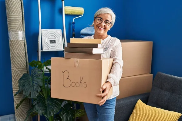 Middle Age Woman Smiling Confident Holding Books Package New Home — ストック写真