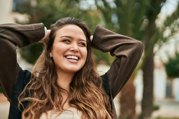 年轻的惊慌失措的女人笑着站在城里 — 图库照片