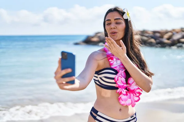 若いですヒスパニック女性身に着けていますビキニ作ります自画撮りスマートフォンによって海辺 — ストック写真