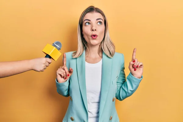 Beautiful Caucasian Woman Being Interviewed Reporter Holding Microphone Amazed Surprised — Stock Photo, Image