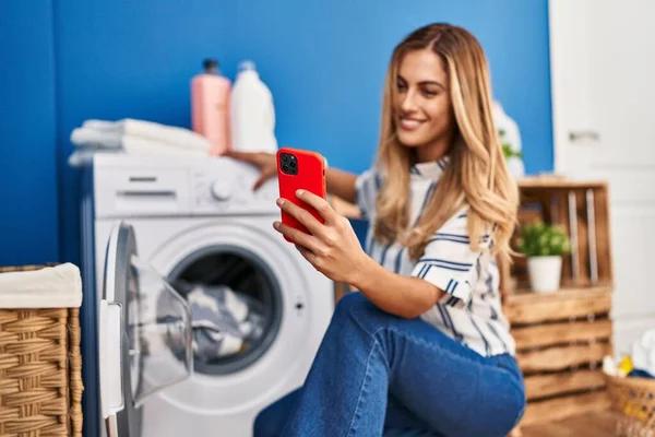 Ung Blond Kvinna Använder Smartphone Och Tvätta Kläder Tvättstuga — Stockfoto