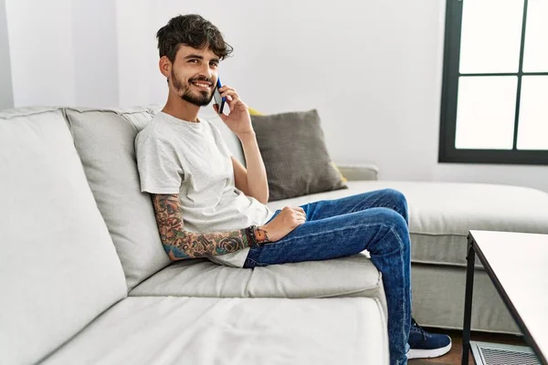 Ung Latinamerikan Man Med Smartphone Sitter Soffan Hemma — Stockfoto