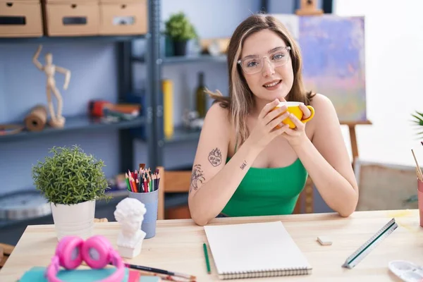 在艺术工作室 年轻的女画家在笔记本上画画喝咖啡 — 图库照片