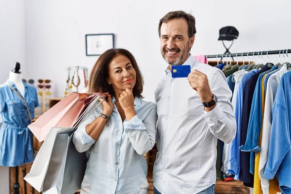 Hispanic Middle Age Couple Holding Shopping Bags Credit Card Looking — Stockfoto