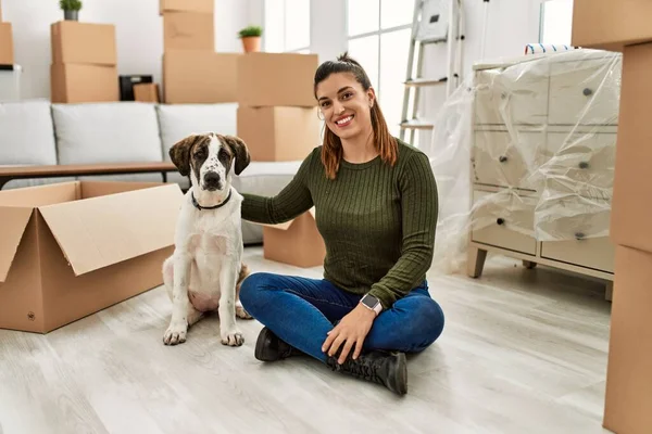 Young woman smiling confident hugging dog at home