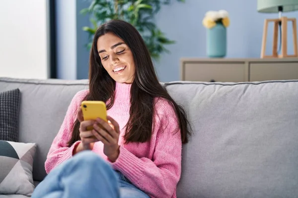 Mujer Hispana Joven Usando Teléfono Inteligente Sentado Sofá Casa — Foto de Stock