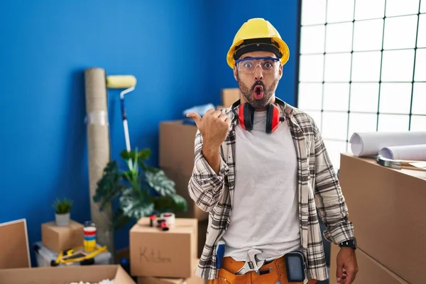 Young Hispanic Man Beard Working Home Renovation Surprised Pointing Hand — Stockfoto