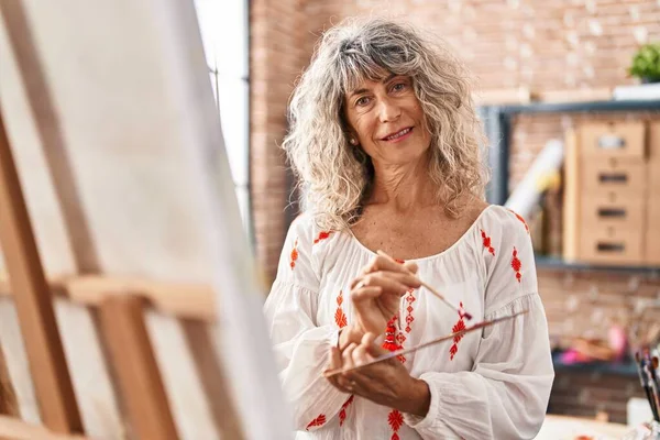 中年妇女艺术家在艺术工作室微笑而自信地画画 — 图库照片