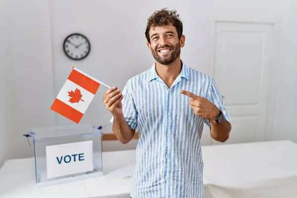 Молодой Красивый Мужчина Выборах Политическую Кампанию Держа Флаг Канады Улыбаясь — стоковое фото
