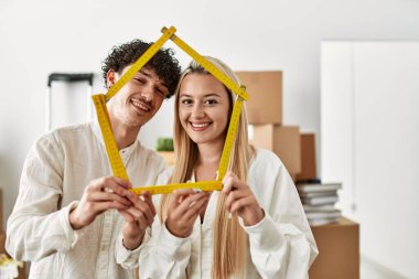 Genç ve güzel bir çift gülümsüyor. Mutlu ev projeleri..