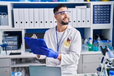 Genç Arap bilim adamı. Laboratuvarda çalışan panoya yazı yazıyor.