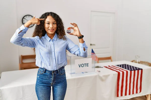 一本の指で頭を指差して笑顔で投票することによって政治運動に立っている美しいヒスパニック系の女性 素晴らしいアイデアや考え 良い記憶 — ストック写真