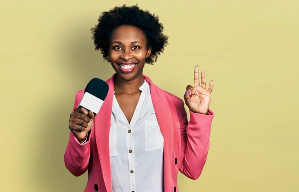 Африканська Американка Волоссям Афроамериканців Тримає Мікрофон Репортера Показує Пальцями Усміхаючись — стокове фото