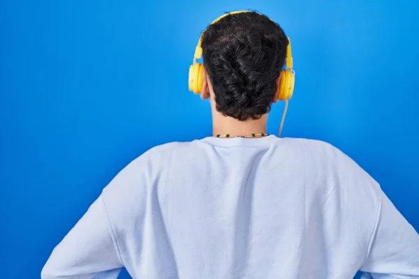 Non Binary Person Listening Music Using Headphones Standing Backwards Looking — Stockfoto