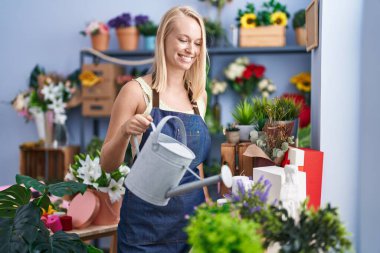 Çiçekçide kendine güvenen genç sarışın bir çiçekçi.