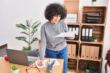 Young middle east woman business worker writing on document working at office