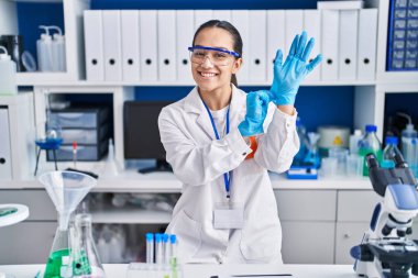Laboratuvarda eldiven giyen genç İspanyol bilim kadını.